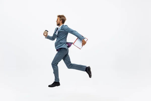 Muž v kancelářských šatech běhá, běhá na bílém pozadí. Neobvyklý pohled obchodníka v pohybu, akce. Sport, zdravý životní styl. — Stock fotografie