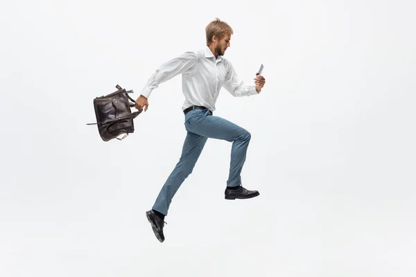 Muž v kancelářských šatech běhá, běhá na bílém pozadí. Neobvyklý pohled obchodníka v pohybu, akce. Sport, zdravý životní styl. — Stock fotografie