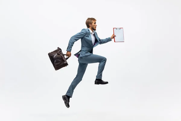 Hombre con ropa de oficina corriendo, corriendo sobre fondo blanco. Mirada inusual para hombre de negocios en movimiento, acción. Deporte, estilo de vida saludable . — Foto de Stock