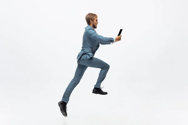 Homem de roupa de escritório a correr, a correr sobre fundo branco. Um olhar incomum para o homem de negócios em movimento, ação. Desporto, estilo de vida saudável . — Fotografia de Stock