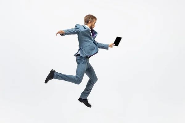 Man in kantoorkleding loopt, jogt op een witte achtergrond. Ongebruikelijke kijk voor zakenman in beweging, actie. Sport, gezonde levensstijl. — Stockfoto