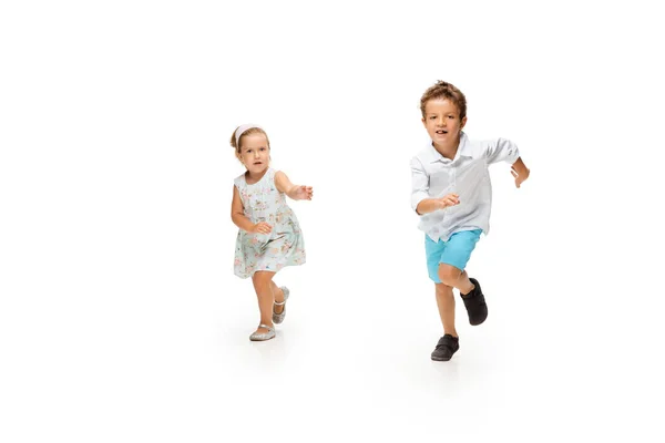 Enfants heureux, petit garçon caucasien et fille sautant et courant isolé sur fond blanc — Photo