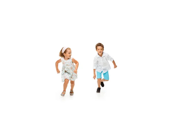 Счастливые дети, маленький кавказский мальчик и девочка прыгают и бегают изолированные на белом фоне — стоковое фото