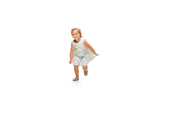 Счастливая маленькая кавказская девочка прыгает и бегает изолированно на белом фоне — стоковое фото