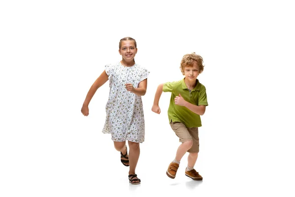 Feliz niña caucásica y chico saltando y corriendo aislado sobre fondo blanco — Foto de Stock