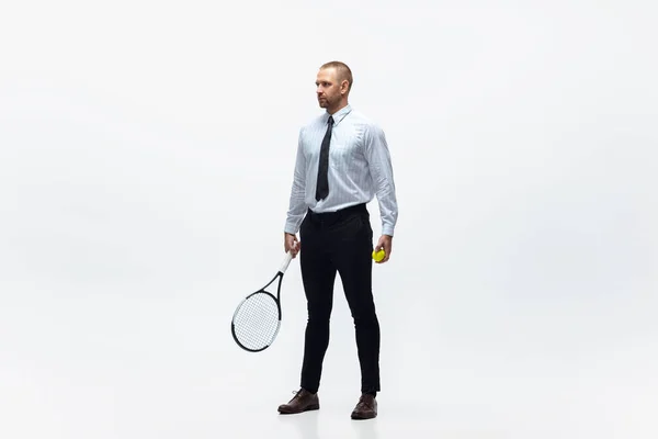 Hora do movimento. Homem em roupas de escritório joga tênis isolado no fundo do estúdio branco . — Fotografia de Stock