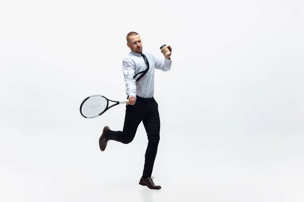Ώρα για κίνηση. Άντρας με ρούχα γραφείου παίζει τένις απομονωμένος σε λευκό φόντο στούντιο. — Φωτογραφία Αρχείου