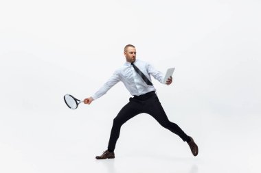 Time for movement. Man in office clothes plays tennis isolated on white studio background. clipart