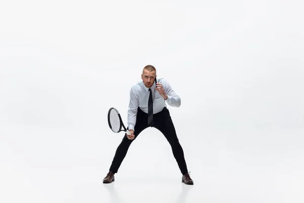 E 'ora di muoversi. Uomo in abiti da ufficio gioca a tennis isolato su sfondo bianco studio. — Foto Stock