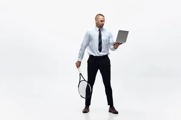 Tijd voor beweging. Man in kantoorkleding speelt tennis geïsoleerd op witte studio achtergrond. — Stockfoto