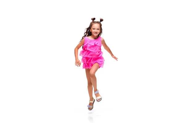 Счастливая маленькая кавказская девочка прыгает и бегает изолированно на белом фоне — стоковое фото