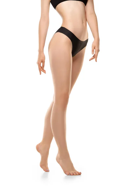 Schöne weibliche Beine, Knöpfe und Bauch isoliert auf weißem Hintergrund. Sportlicher, sinnlicher Körper mit gepflegter Haut in Unterwäsche. — Stockfoto