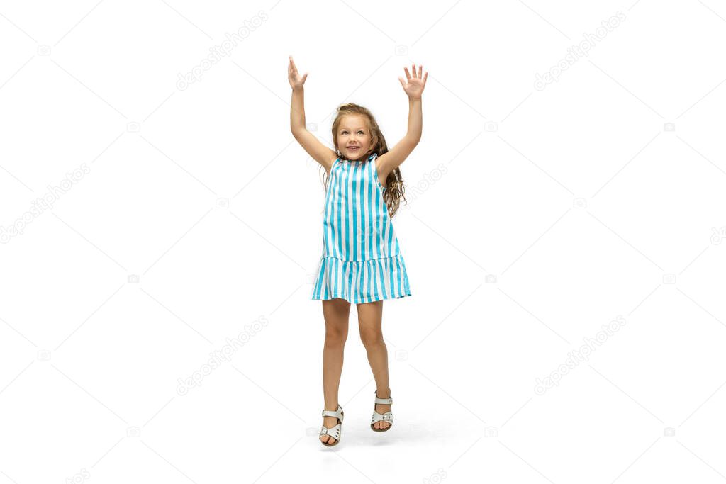 Happy little caucasian girl jumping and running isolated on white background