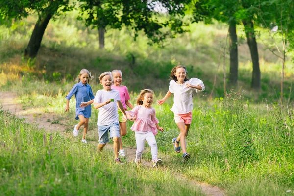 Niños, niños corriendo en el prado a la luz del sol — Foto de Stock