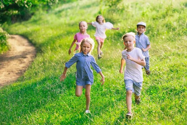 Enfants, enfants courant sur la prairie en été la lumière du soleil — Photo