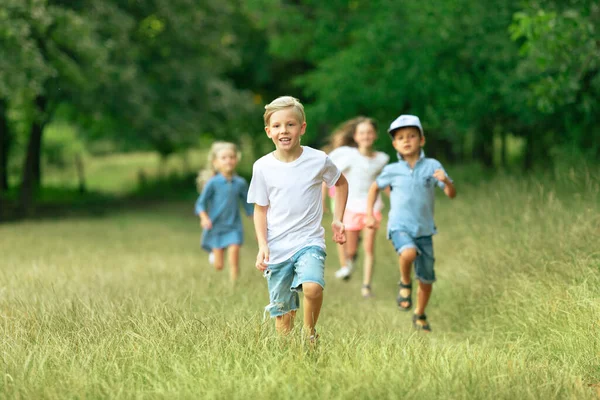Дети, дети, бегущие по лугу летом на солнце — стоковое фото