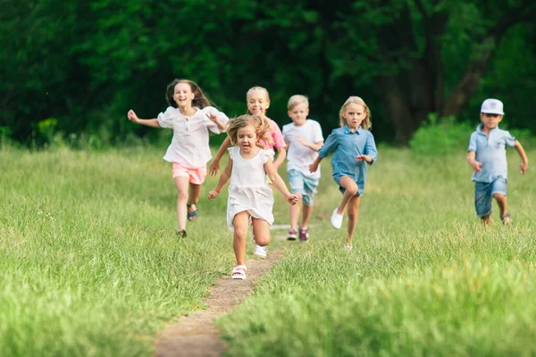 Niños, niños corriendo en el prado a la luz del sol — Foto de Stock