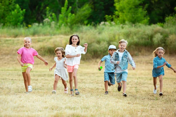 Crianças, crianças correndo no prado na luz do sol de verão — Fotografia de Stock
