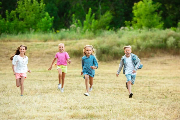 Bambini, bambini che corrono sul prato in estate luce del sole — Foto Stock