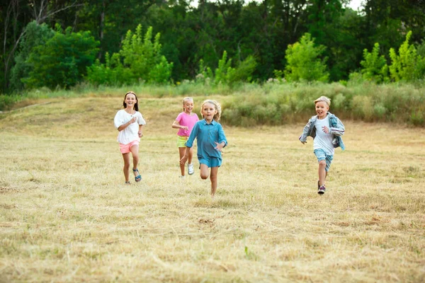 Παιδιά, παιδιά τρέχουν στο λιβάδι τα καλοκαίρια. — Φωτογραφία Αρχείου