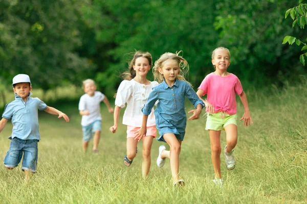 Kids, children running on meadow in summers sunlight Stock Photo