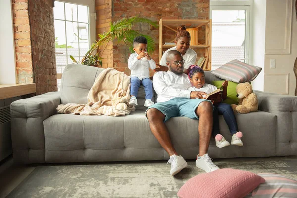 Young african family during quarantine, insulation spending time together at home