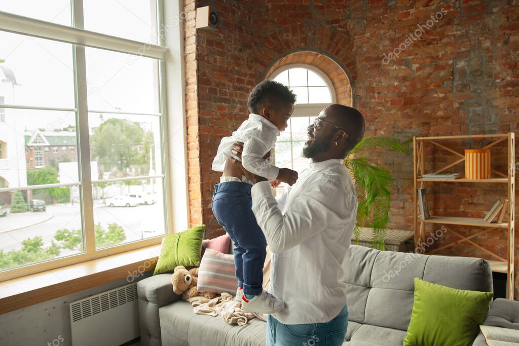 Young african family during quarantine, insulation spending time together at home