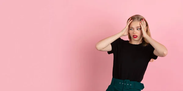 Jovem mulher emocional no fundo do estúdio rosa. Emoções humanas, conceito de expressão facial . — Fotografia de Stock