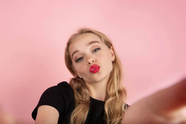 Jovem mulher emocional no fundo do estúdio rosa. Emoções humanas, conceito de expressão facial . — Fotografia de Stock