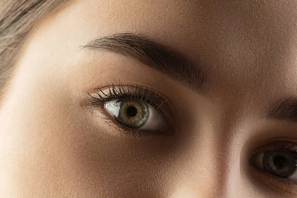 Close-up van gezicht van mooie blanke jonge vrouw, focus op ogen. Menselijke emoties, gezichtsuitdrukking, kosmetologie, lichaams- en huidverzorgingsconcept. — Stockfoto