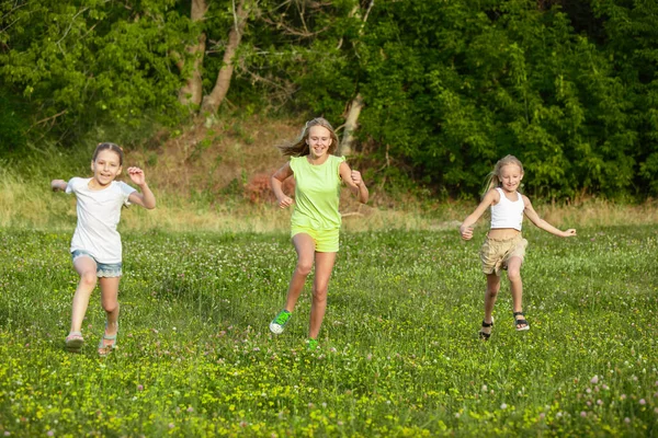 Kinder, Kinder, die im Sommer auf der Wiese laufen — Stockfoto