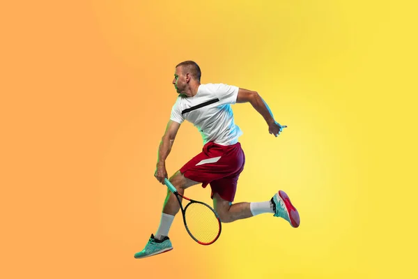 Beyaz tenli profesyonel sporcu stüdyo arka planında neon ışıklı tenis oynuyor. — Stok fotoğraf