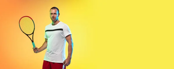 Hombre caucásico deportista profesional jugando al tenis en el fondo del estudio en luz de neón —  Fotos de Stock