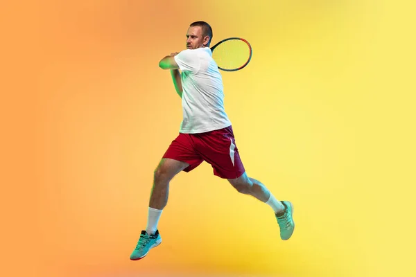 Blanke mannelijke professionele sportman tennissen op studio achtergrond in neon licht — Stockfoto