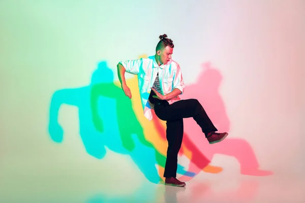 Jonge mooie man dansen hip-hop, straat stijl geïsoleerd op studio achtergrond in neon licht — Stockfoto