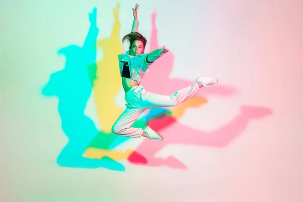 Jong mooi vrouw dansen hip-hop, straat stijl geïsoleerd op studio achtergrond in neon licht — Stockfoto