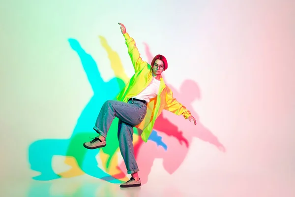 Joven hermosa mujer bailando hip-hop, estilo de calle aislado en el fondo del estudio en luz de neón —  Fotos de Stock