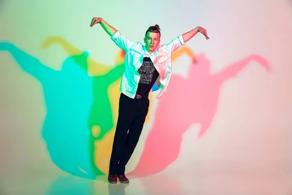 Jonge mooie man dansen hip-hop, straat stijl geïsoleerd op studio achtergrond in neon licht — Stockfoto