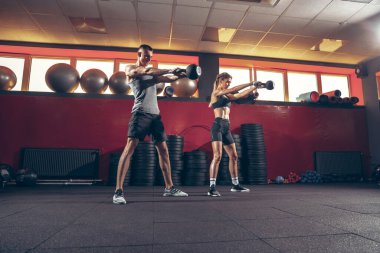 Güzel, genç, sportif çift eğitimi, spor salonunda birlikte antrenman.