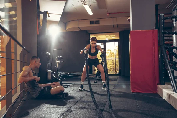 Schöne junge sportliche Paar Training, Workout im Fitnessstudio zusammen — Stockfoto