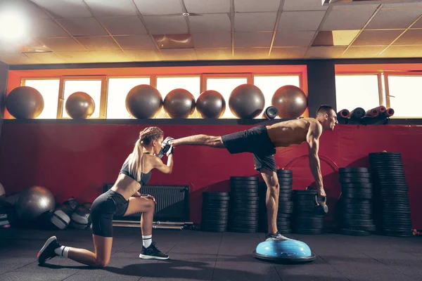 Beautiful young sporty couple training, workout in gym together — Stock Photo, Image