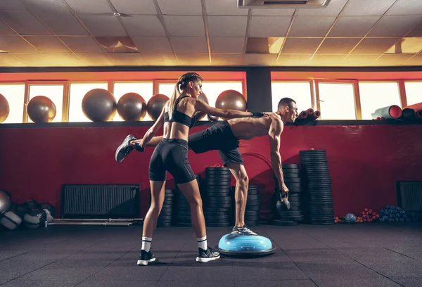 Hermosa joven pareja deportiva de entrenamiento, entrenamiento en el gimnasio juntos — Foto de Stock