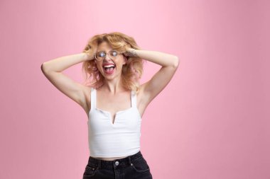 Pembe stüdyo arka planında izole edilmiş beyaz kadın portresi. Güzel bir kadın model. İnsan duyguları kavramı, yüz ifadesi, satış, reklam, gençlik kültürü.