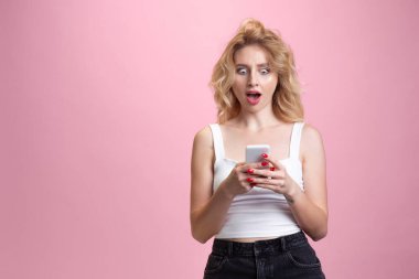 Pembe stüdyo arka planında izole edilmiş beyaz kadın portresi. Güzel bir kadın model. İnsan duyguları kavramı, yüz ifadesi, satış, reklam, gençlik kültürü.