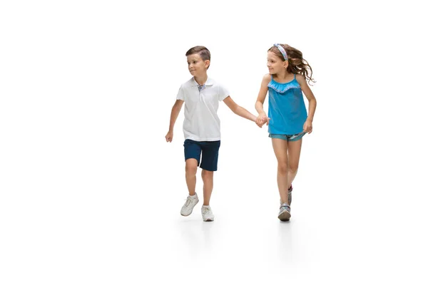 Щаслива маленька біла дівчинка і хлопчик стрибають і бігають ізольовано на білому тлі — стокове фото
