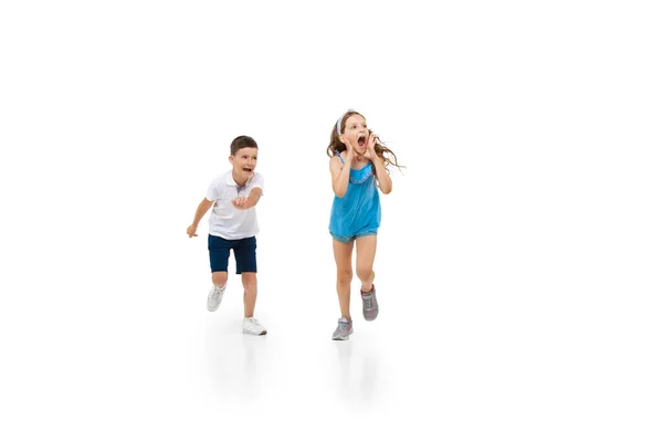 Feliz niña caucásica y chico saltando y corriendo aislado sobre fondo blanco — Foto de Stock