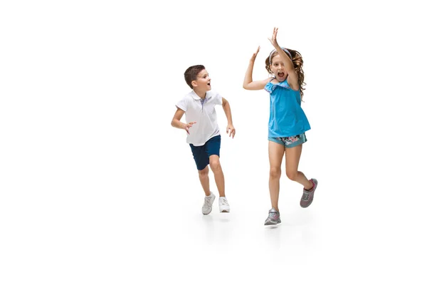 Glückliche kleine kaukasische Mädchen und Jungen springen und laufen isoliert auf weißem Hintergrund — Stockfoto