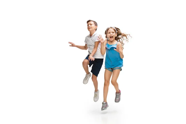 Щаслива маленька біла дівчинка і хлопчик стрибають і бігають ізольовано на білому тлі — стокове фото