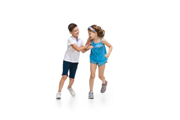 Feliz pouco caucasiano menina e menino pulando e correndo isolado no fundo branco — Fotografia de Stock