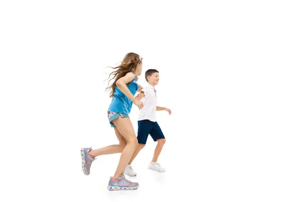 Glückliche kleine kaukasische Mädchen und Jungen springen und laufen isoliert auf weißem Hintergrund — Stockfoto